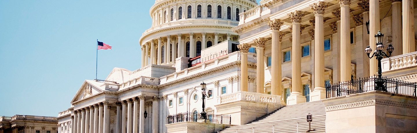 The entrance to the Capitol against a blue sky.