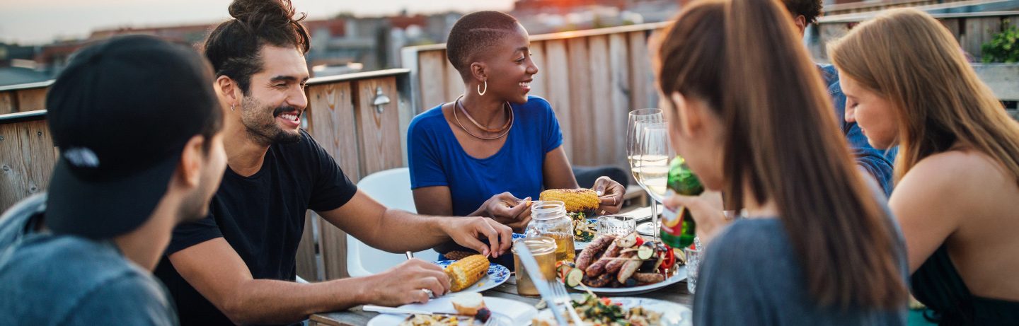 Gruppe von Menschen genießt ein gemeinsames Essen im Freien bei einer entspannten Atmosphäre