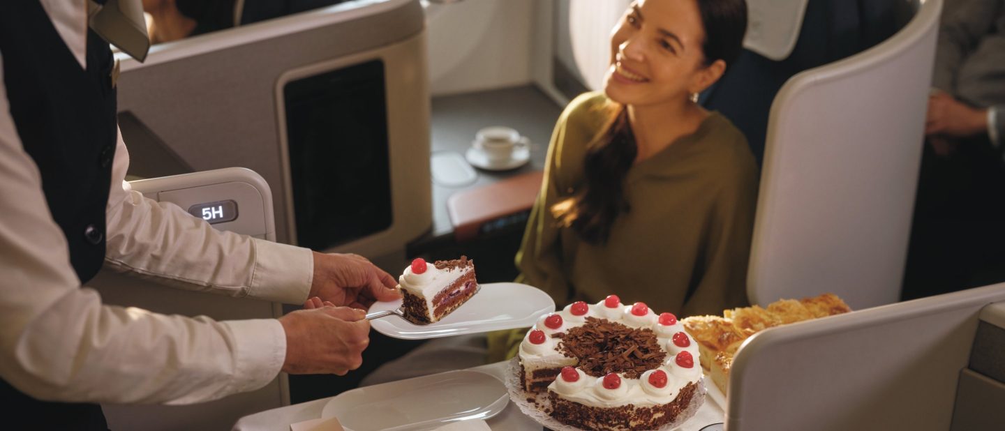 Eine Flugbegleitende und eine Passagierin mit dem Kuchenservice in der Lufthansa Allegris Business Class // A flight attendant and a passenger with the cake service in Lufthansa Allegris Business Class