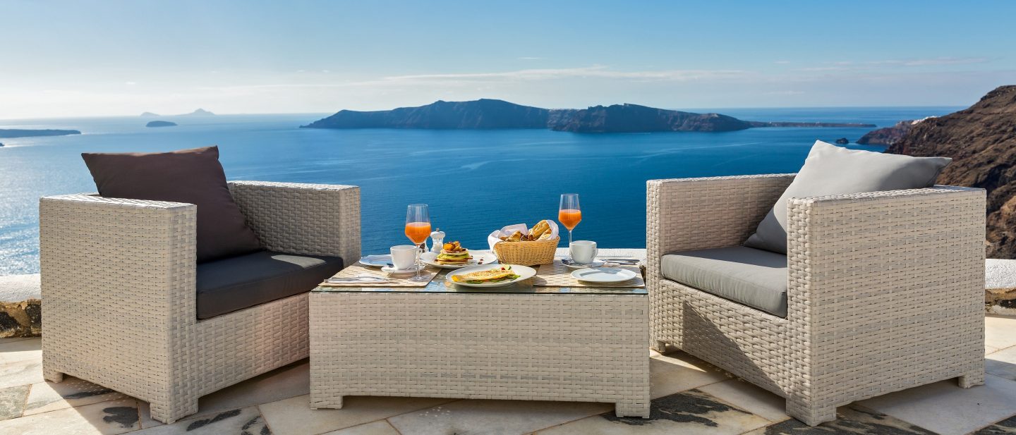 Frühstückstisch auf einer Terrasse mit Blick auf das blaue Meer.