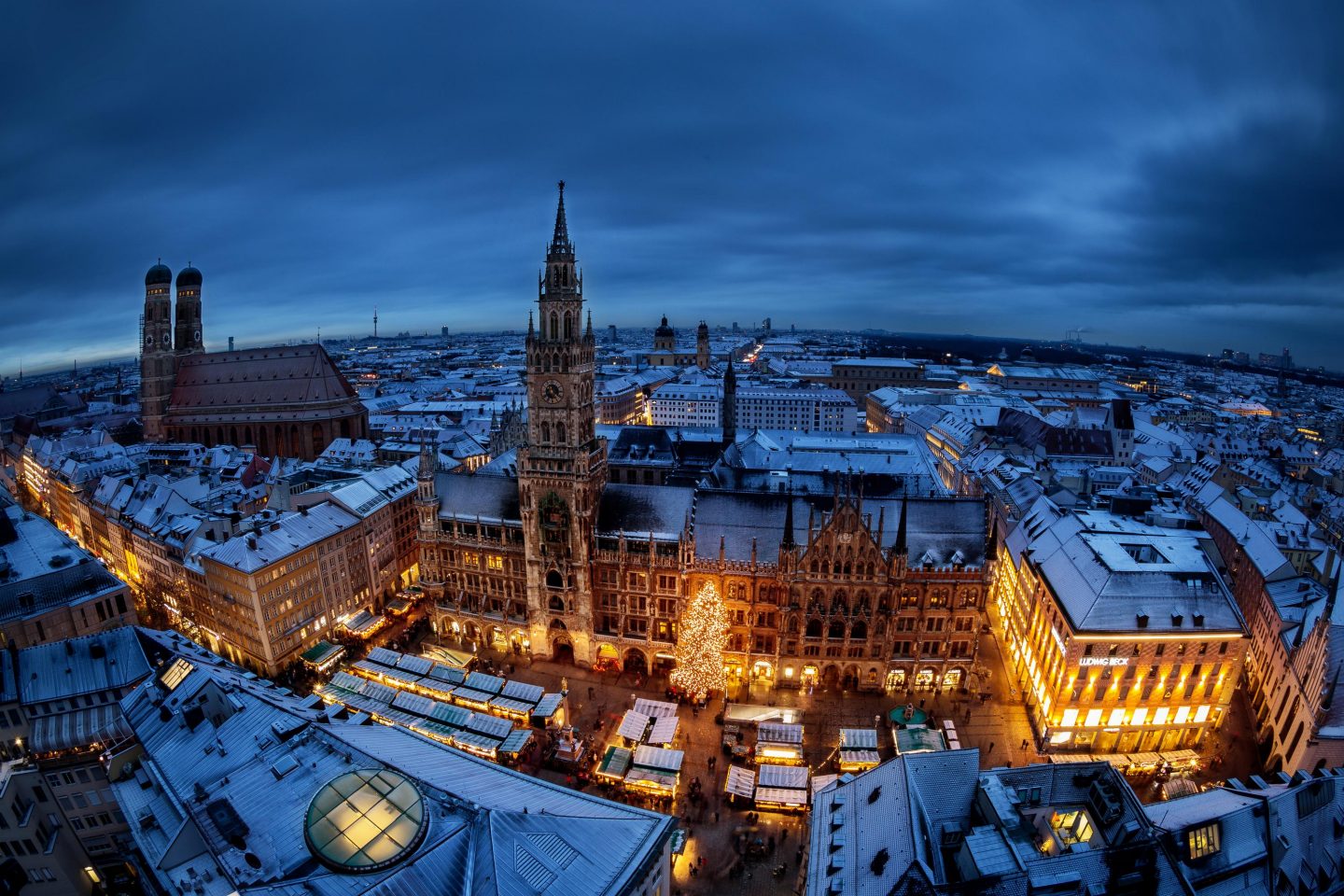 Aerial view of Munichs Marienplatz with its town hall and the Christmas market, during a winter evening in Advent, with snow on the roofs. Snow is pretty rare at this time of the year in Munich. Shot taken from the steeple of Alter Peter" church. Munich, Bavaria, Germany."