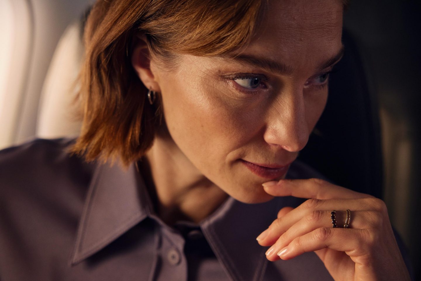 Close-up of a pensive woman on the aircraft.