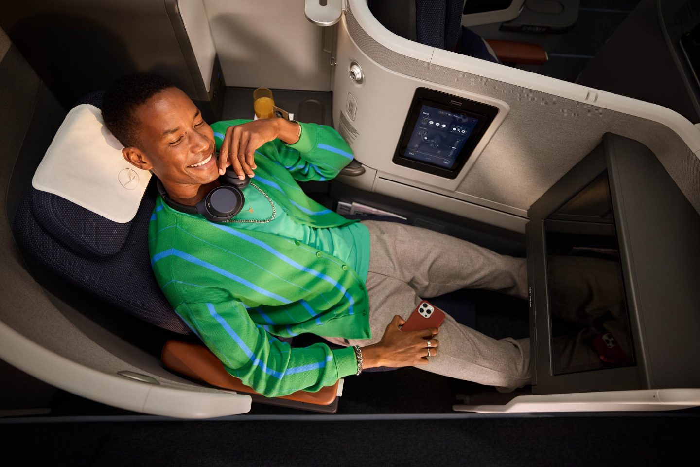 Ein Mann genie&szlig;t seinen Freiraum im Allegris Extra Long Bed in der Business Class. // A man enjoys his space in the Allegris Extra Long Bed in Business Class.