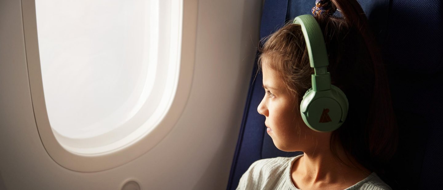 Kind mit gr&radic;&ordm;nen Kopfh&radic;&part;rern sieht aus dem Fenster // Child wearing green Headphones looking out of the window 