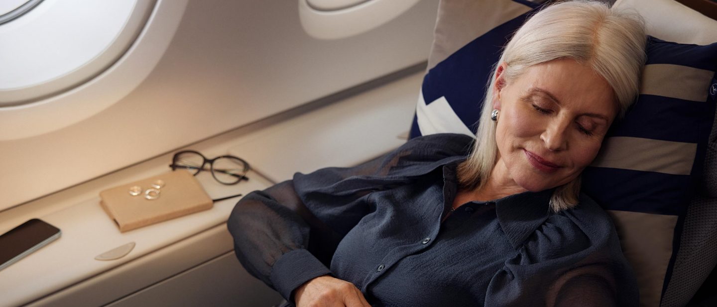 Woman sleeping in a Lufthansa A380 Business Class lie-flat seat.