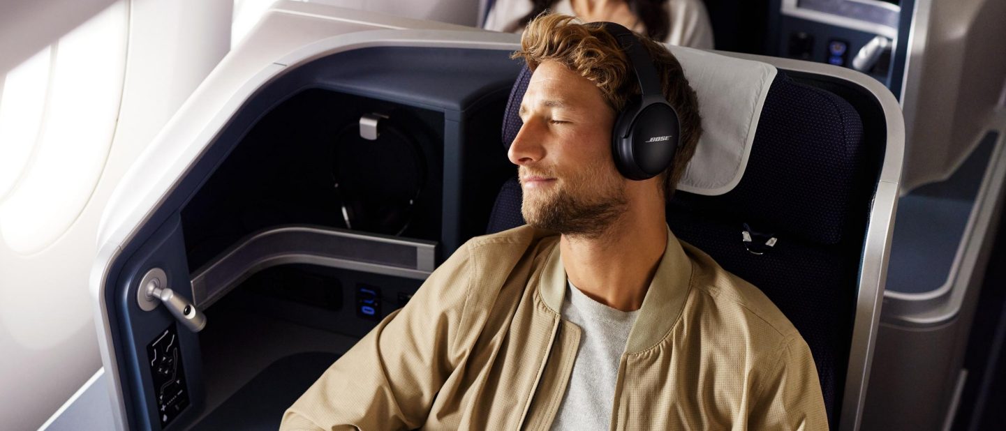 Ein Mann h&radic;&part;rt mit geschlossenen Augen entspannt Musik in der Business Class. // A man listens to music in business class with his eyes closed.