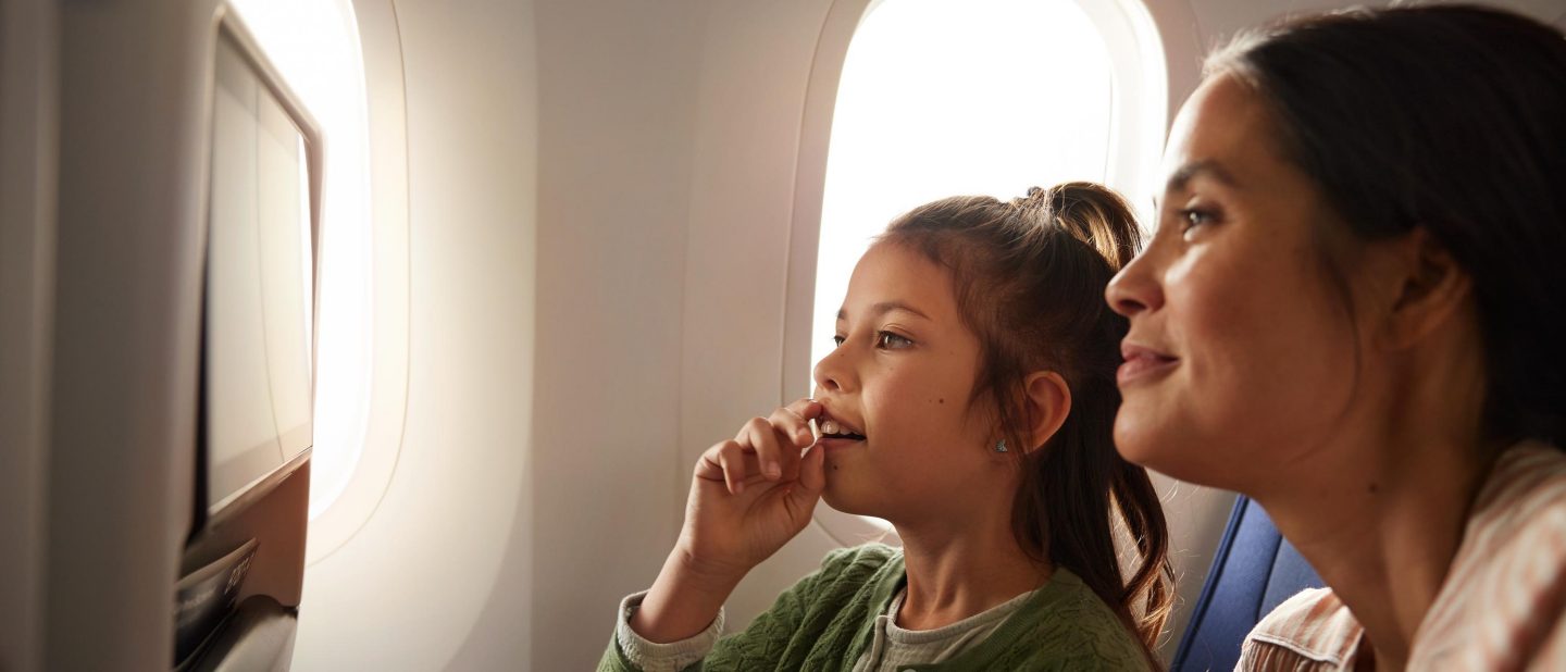 Mutter und Tochter sitzen in der Economy Class und verwenden das Inflight Entertainment System. // Mother and daughter are sitting in Economy Class and are using the Inflight Entertainment System. 