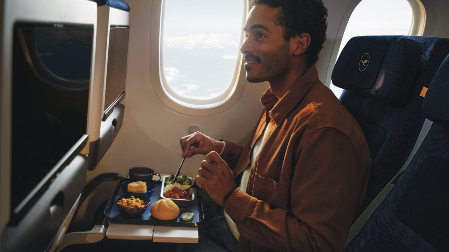 Ein Gast genießt sein Essen in der Lufthansa Allegris Economy Class.