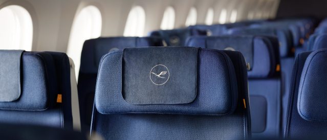 A young man sits in Economy Class on the A380 and looks out of the window.