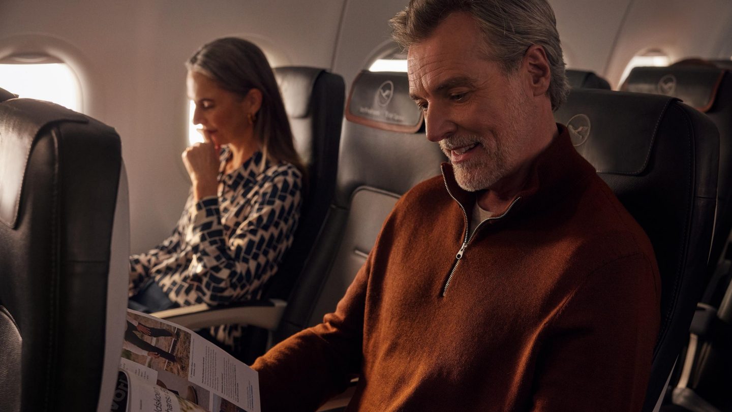 Zwei Passagiere lesen nebeneinander in der Lufthansa Business Class.
