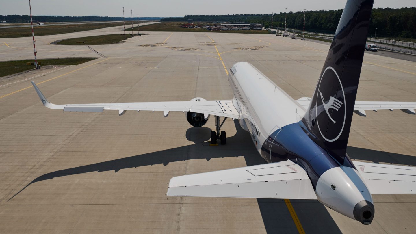 Lufthansa aircraft on the apron; the distinctive logo on the vertical stabilizer is visible.