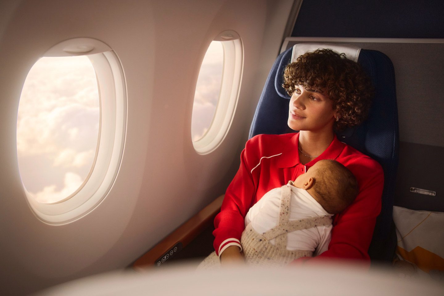 Comfortable flight for mom and baby, enjoying the view from the window.