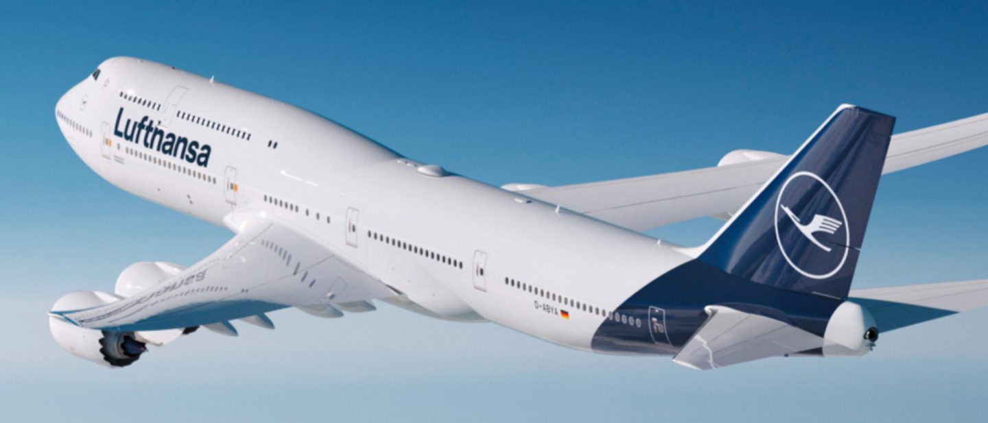 Lufthansa Boeing 747 in flight against clear blue sky.