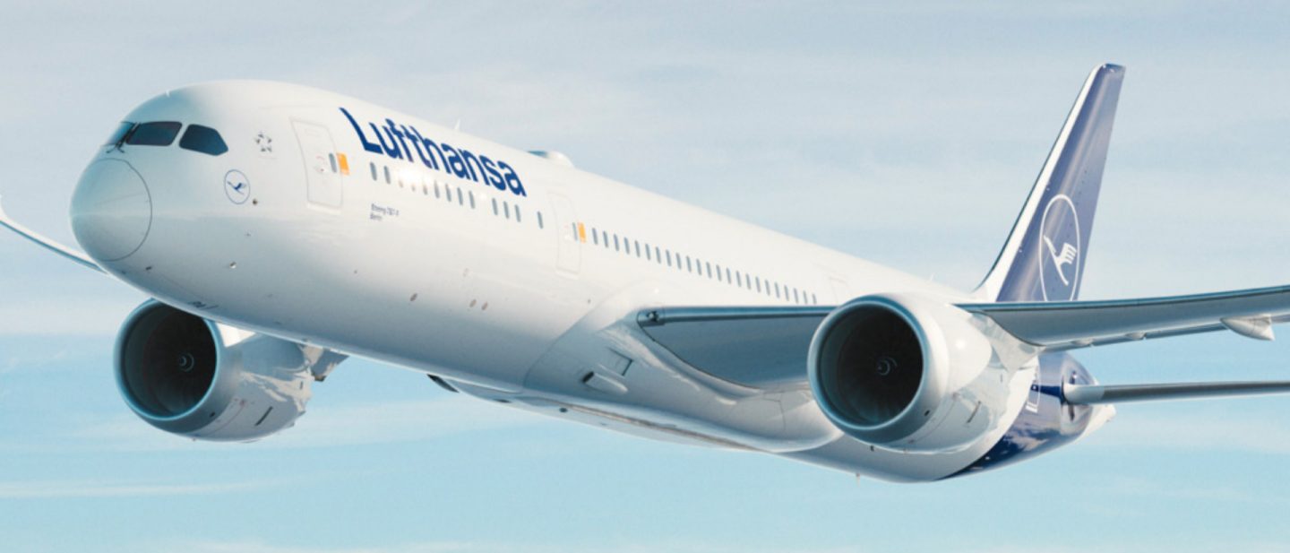 Lufthansa Boeing 787-9 Dreamliner in flight against a blue sky.