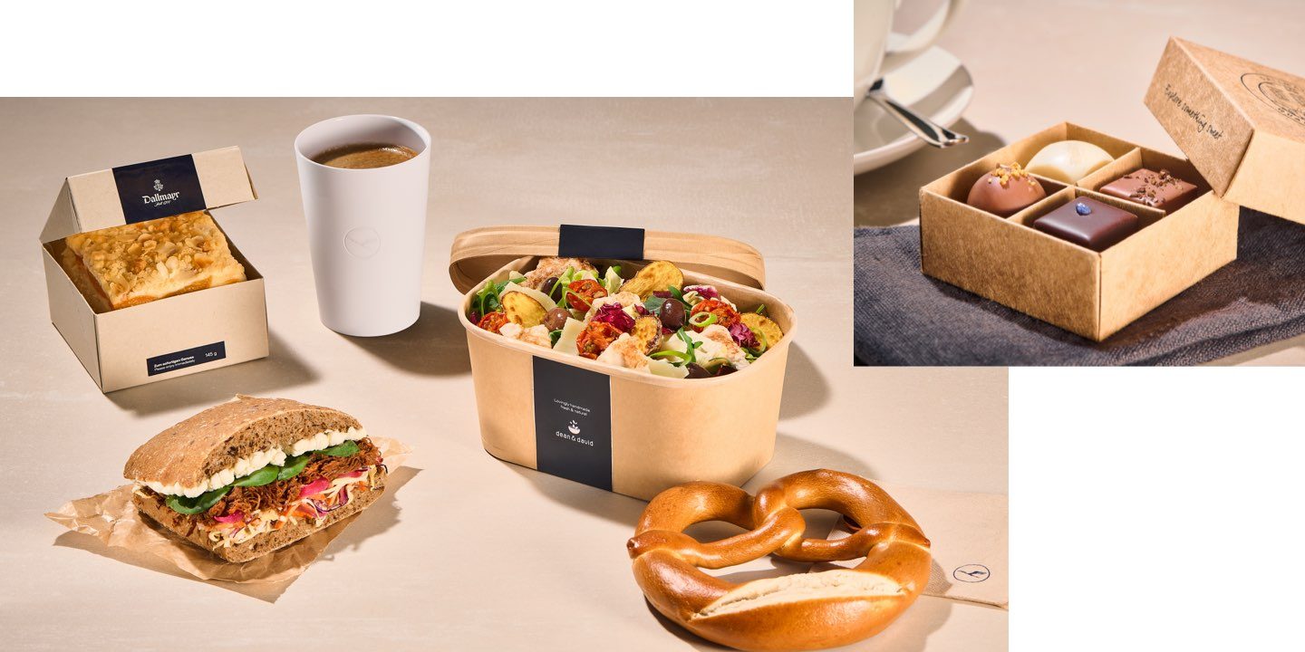 Eine Auswahl an frischen Onboard Delights Snacks, darunter ein Sandwich, Salat, eine Brezel und Kaffee.