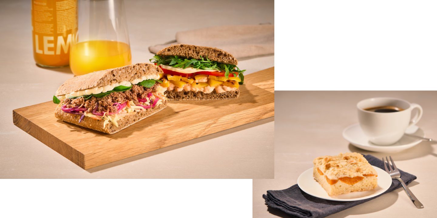 Eine Auswahl an frischen Onboard Delights Snacks, darunter ein Sandwich, Salat, eine Brezel und Kaffee.