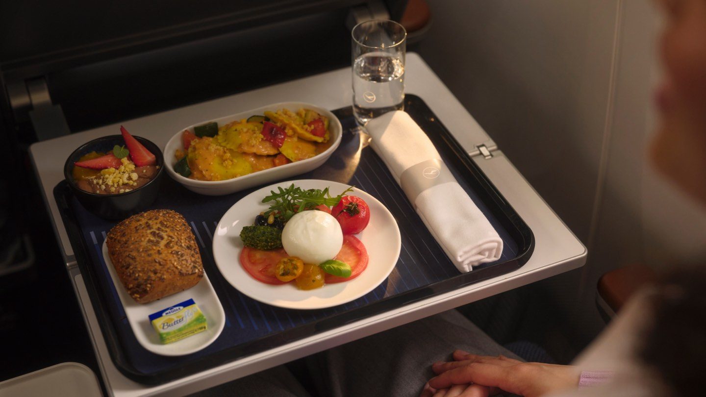 A gourmet meal served on a tray table in Lufthansa Premium Economy Class.