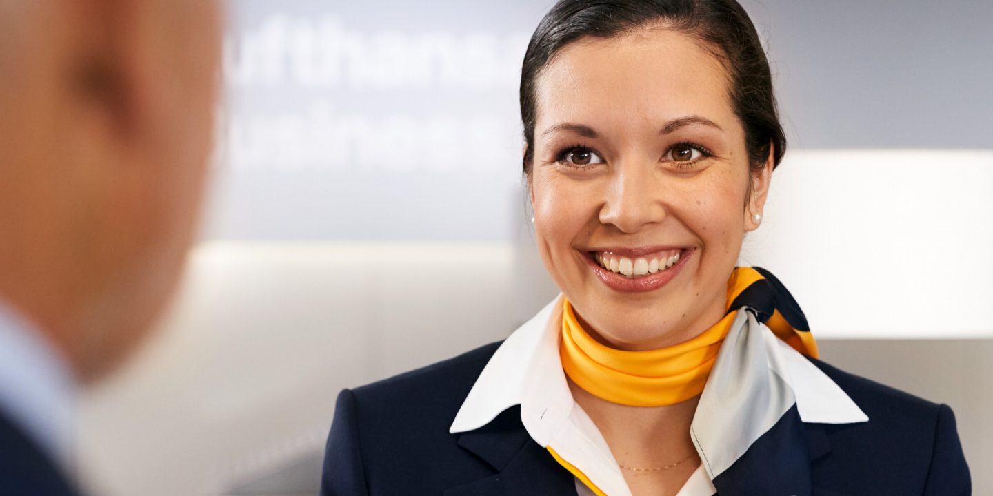 Lufthansa female employee at the desk facing a customer