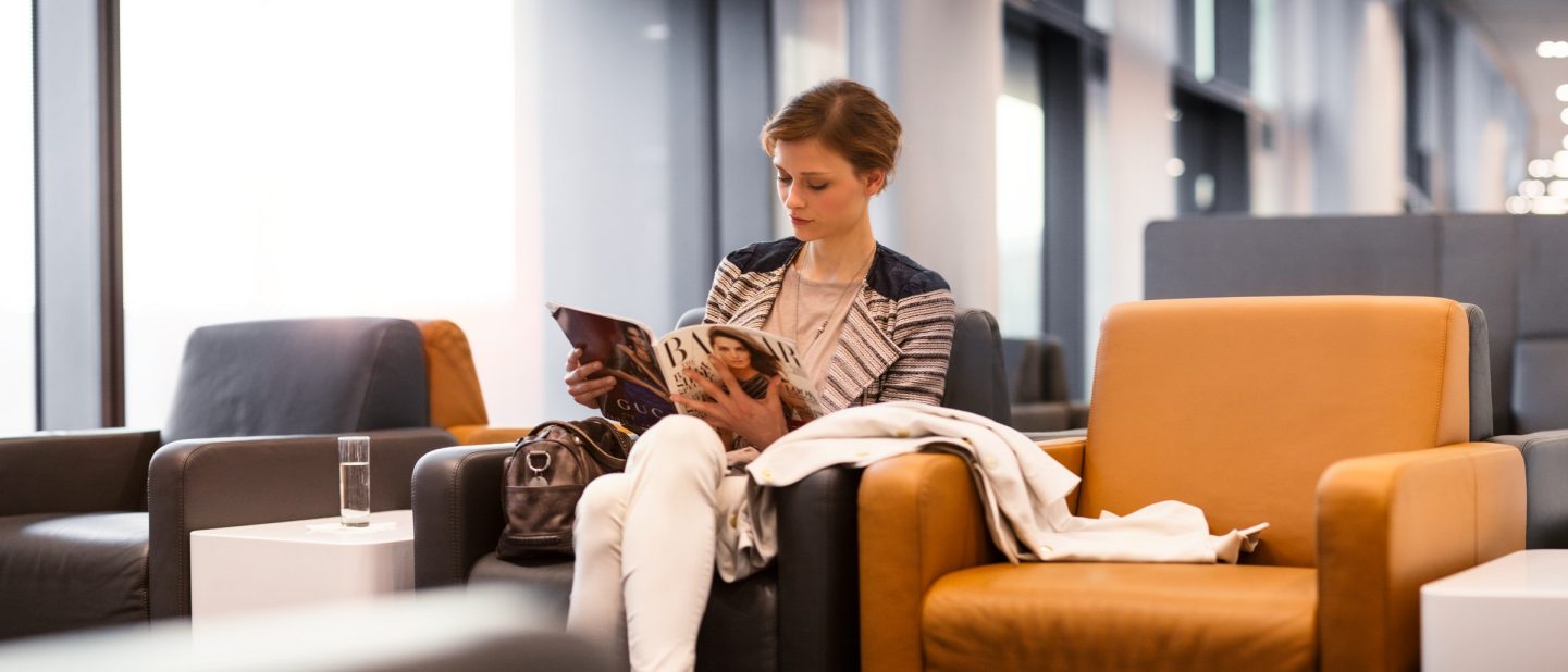 Frau lie?t entspannt in Lufthansa Business Lounge//woman reads relaxed in Lufthansa Business Lounge