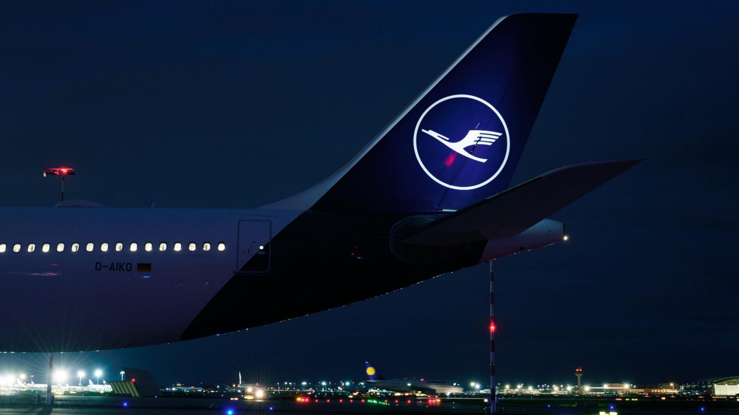 Illustration of a Lufthansa airplane flying over clouds at night