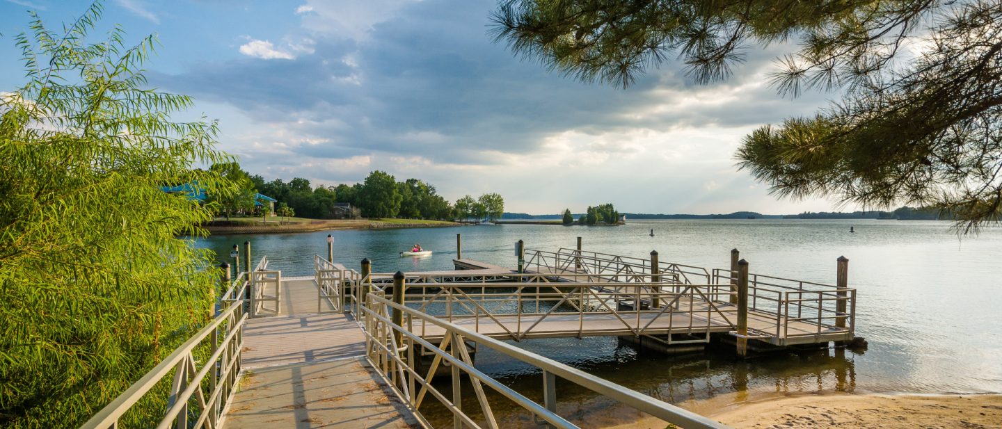 Wooden dock with floating platforms on the shore of Lake Norman, surrounded by trees