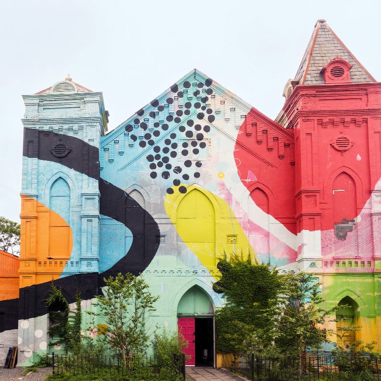 Foto eines bunten Wandgemäldes an einer Kirche in Washington, D. C., das lebhafte geometrische Formen und Muster zeigt