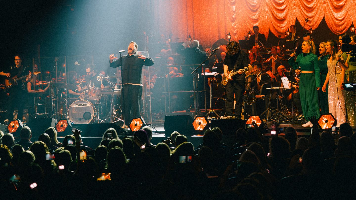 Singer Rea Garvey on stage with his band and the Lufthansa Orchestra during a live concert.