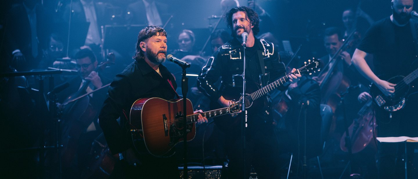 Singer Rea Garvey on stage with his band and the Lufthansa Orchestra during a live concert.