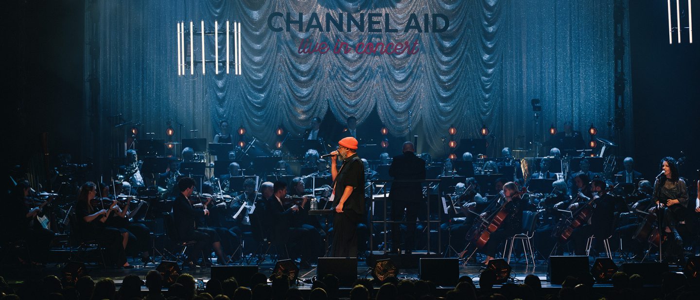 Rapper Samy Deluxe on stage with his band and the Lufthansa Orchestra during a live concert.