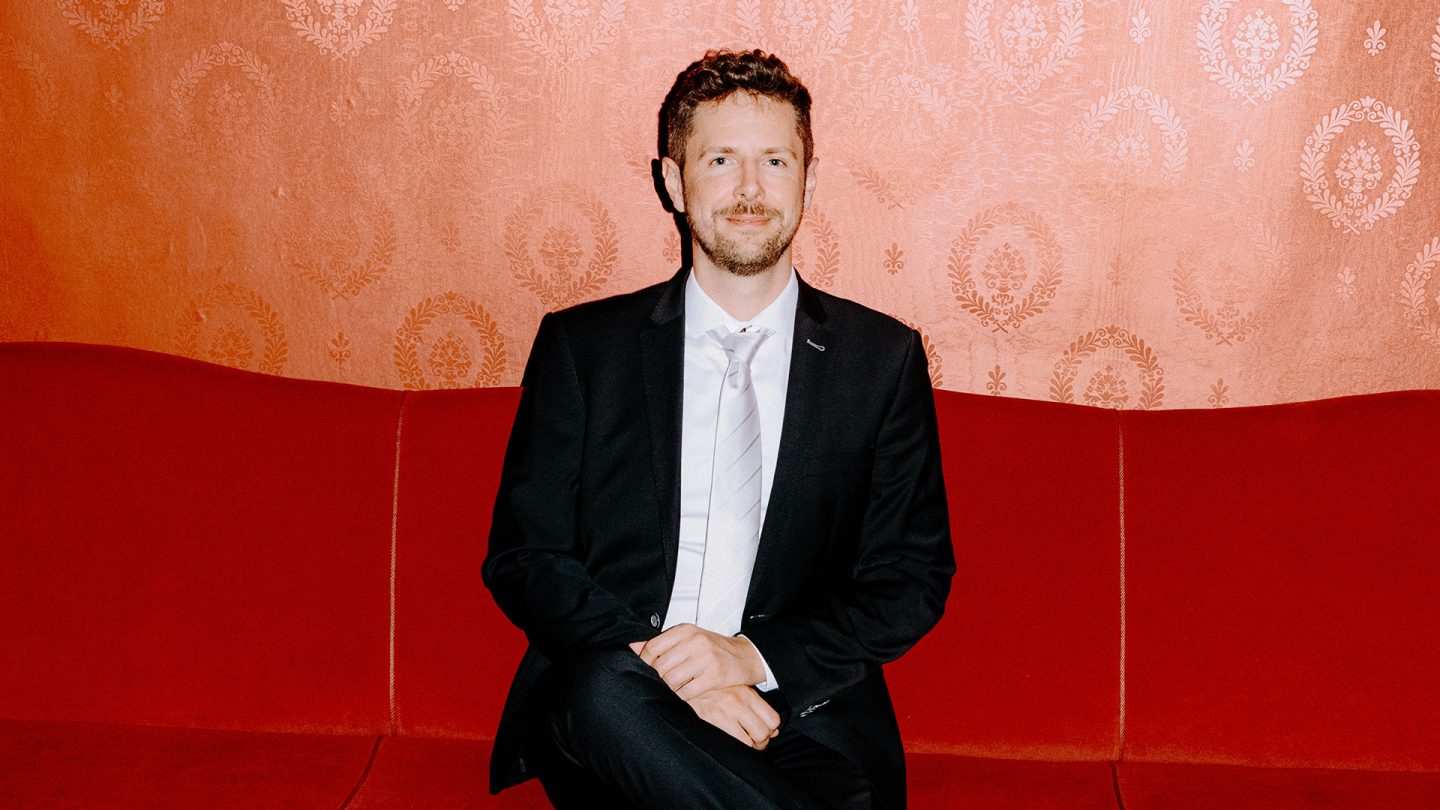 Portrait of a man in a suit in the foyer of the Hamburg Schauspielhaus.