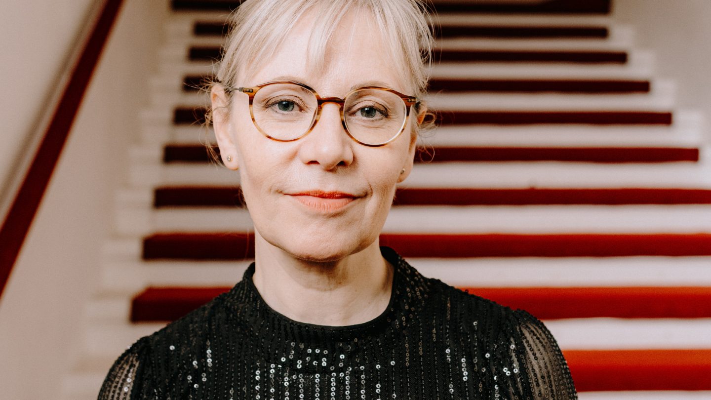 Portrait of a woman in a black sequined shirt in the foyer of the Hamburg Schauspielhaus 