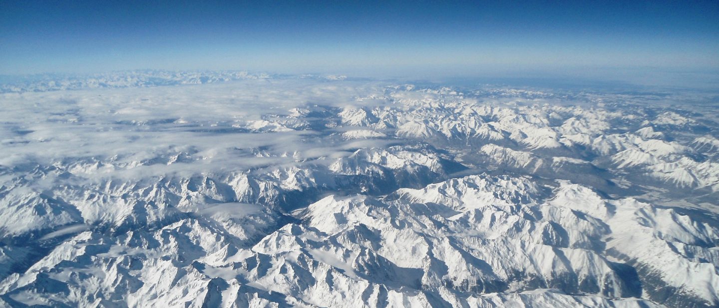 Aerial view of the snow-covered Alps under a clear blue sky