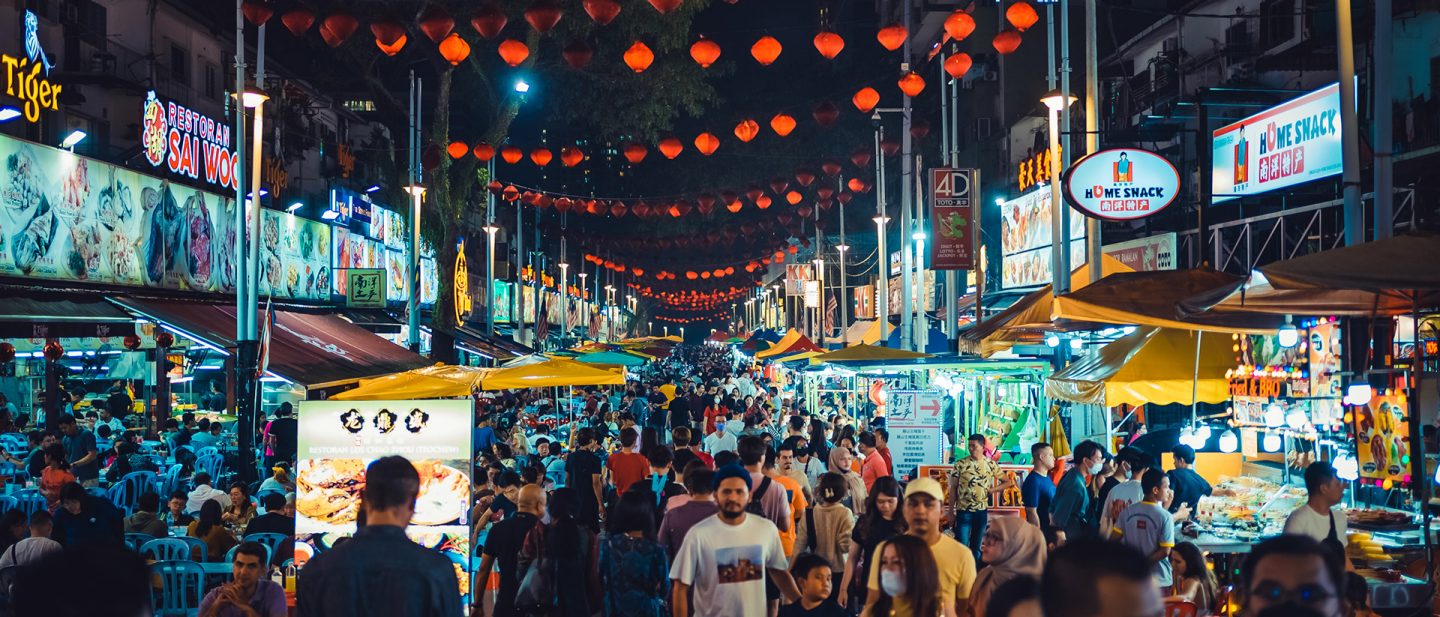 Bustling street food market on Jalan Alor in Kuala Lumpur at night under red lanterns