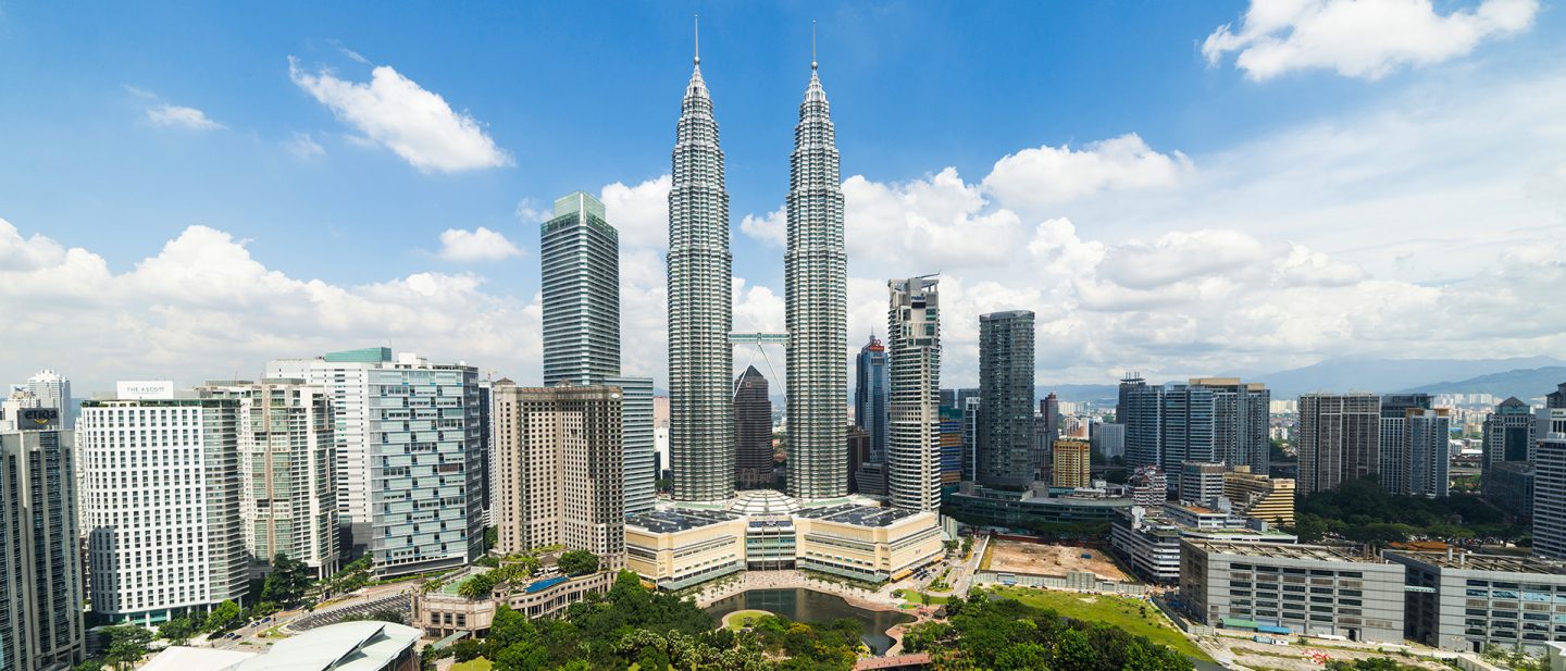 The Petronas Towers rise above the Kuala Lumpur skyline by day