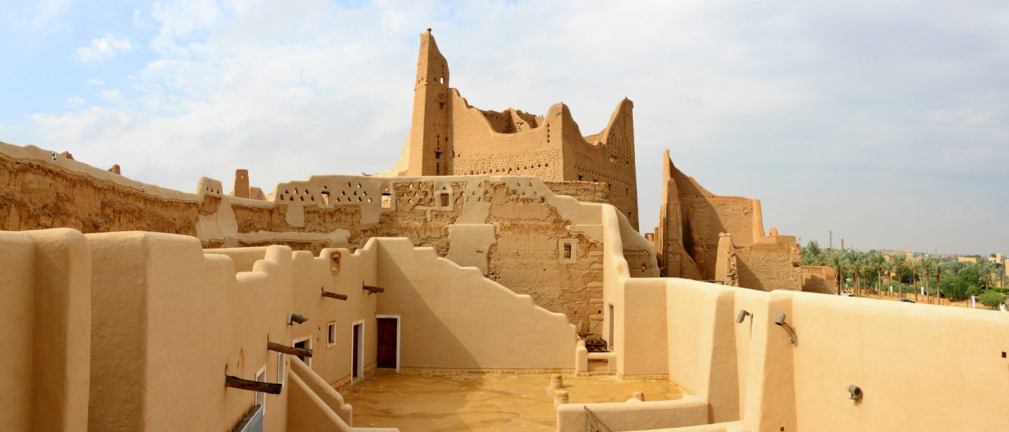 Historic mud-brick buildings and ruins in Diriyah under a cloudy sky