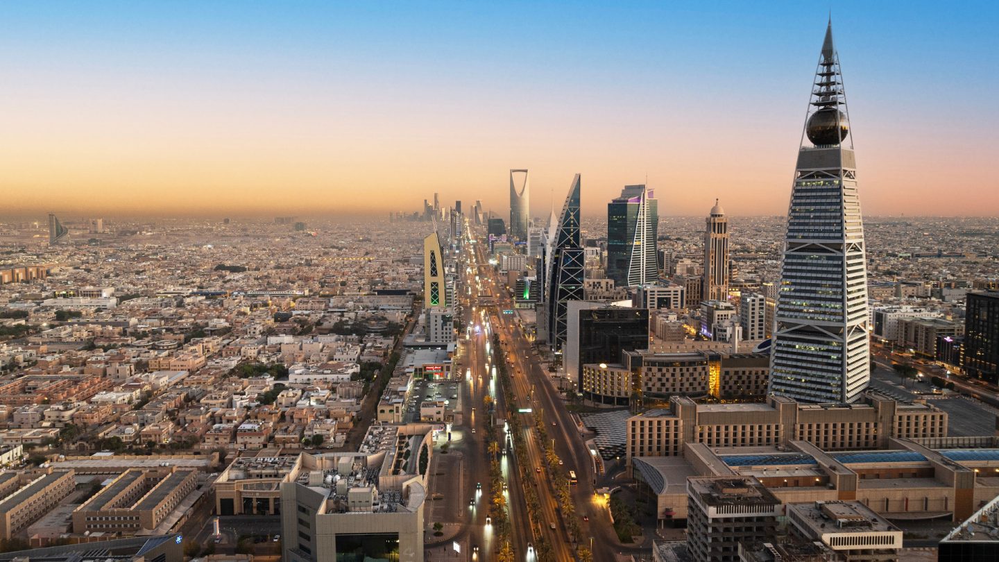 Riyadh skyline at dusk featuring the Al Faisaliyah Center and illuminated city streets