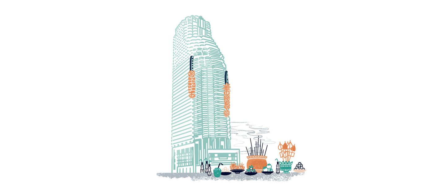 A modern skyscraper with a traditional offering of incense and fruit placed in front