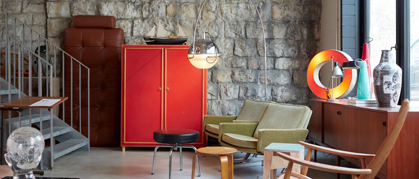 Stylish interior with red cabinet, green couch, and stone walls in a modern room