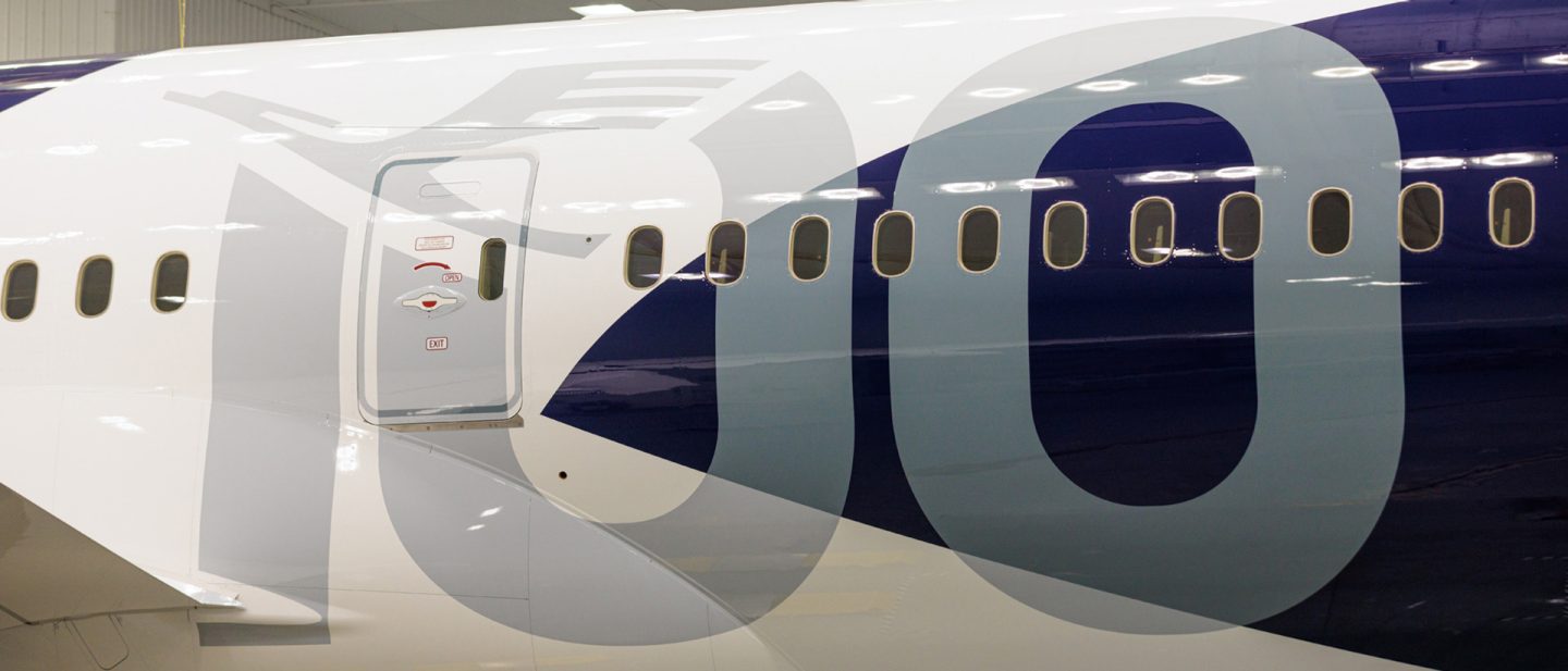 Close-up van de glanzende blauwe en witte romp livery met het nummer '100'