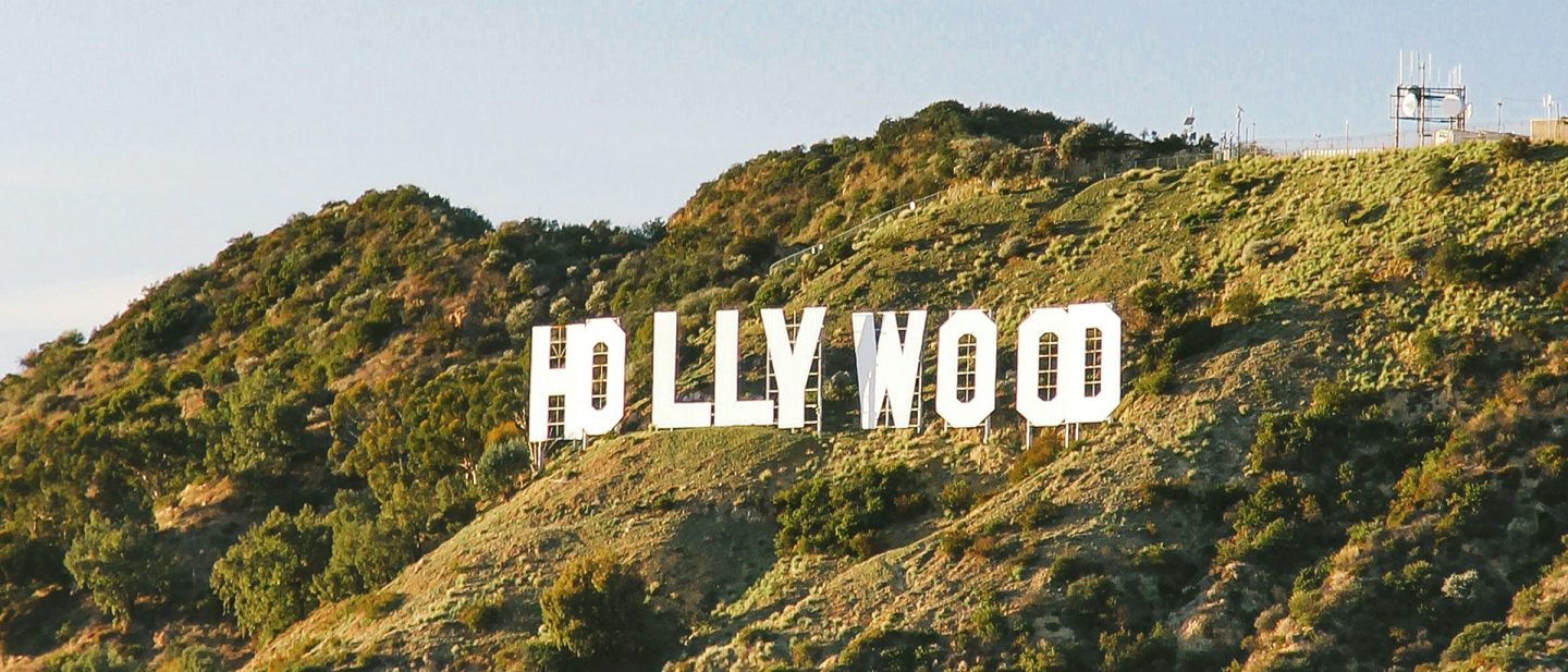 The famous Hollywood sign on a green hillside in Los Angele