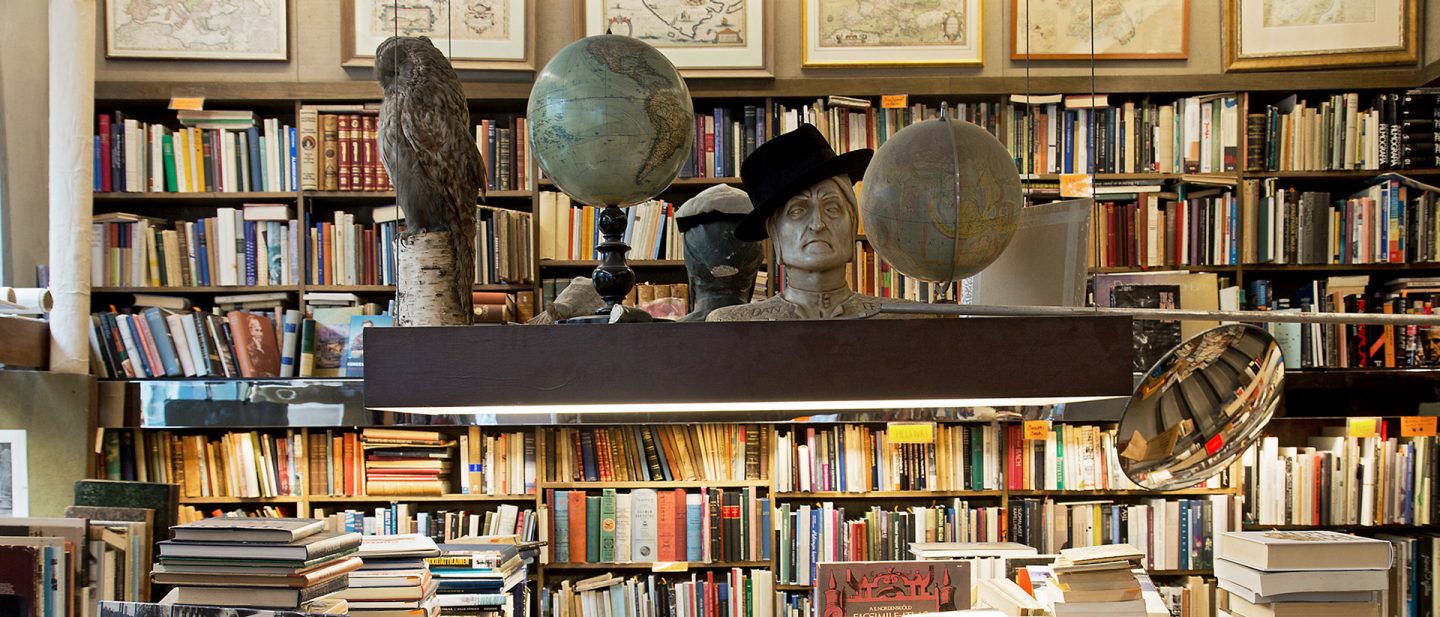 Busts, globes, and books in a densely packed, eclectic bookstore.