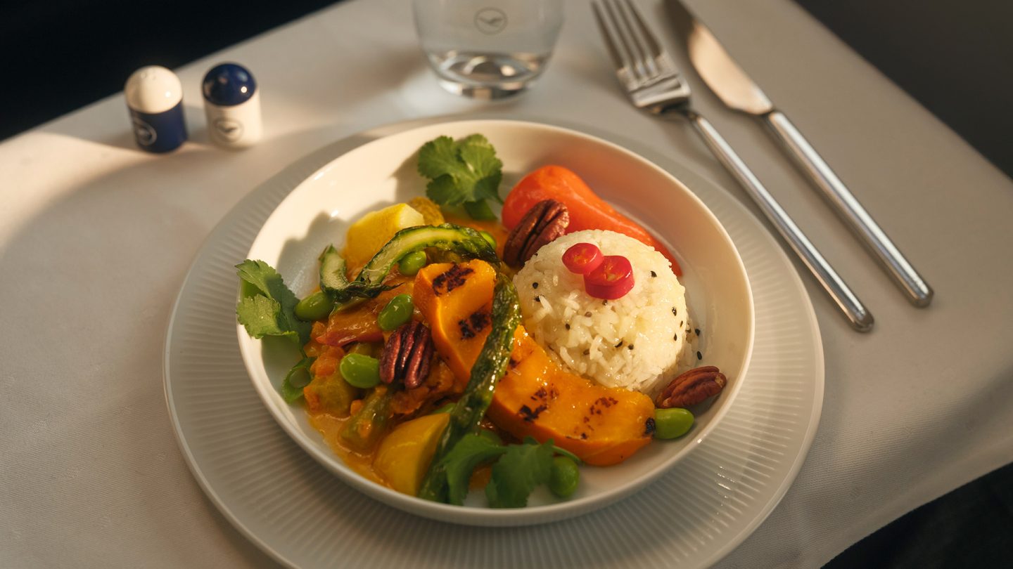 Vegetarian airline meal with rice and vegetables on a plate.