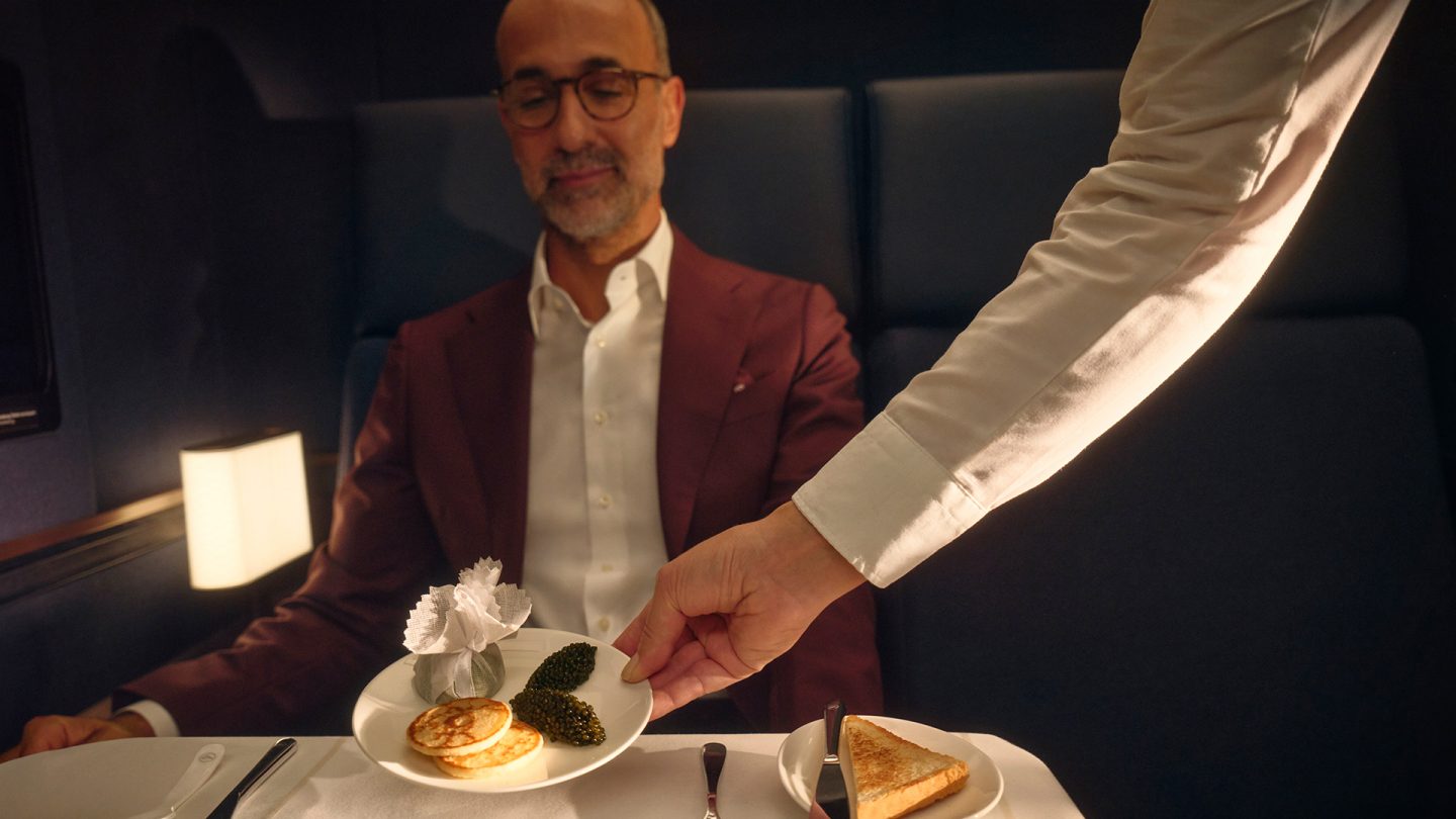 First class passenger is served caviar with blinis.