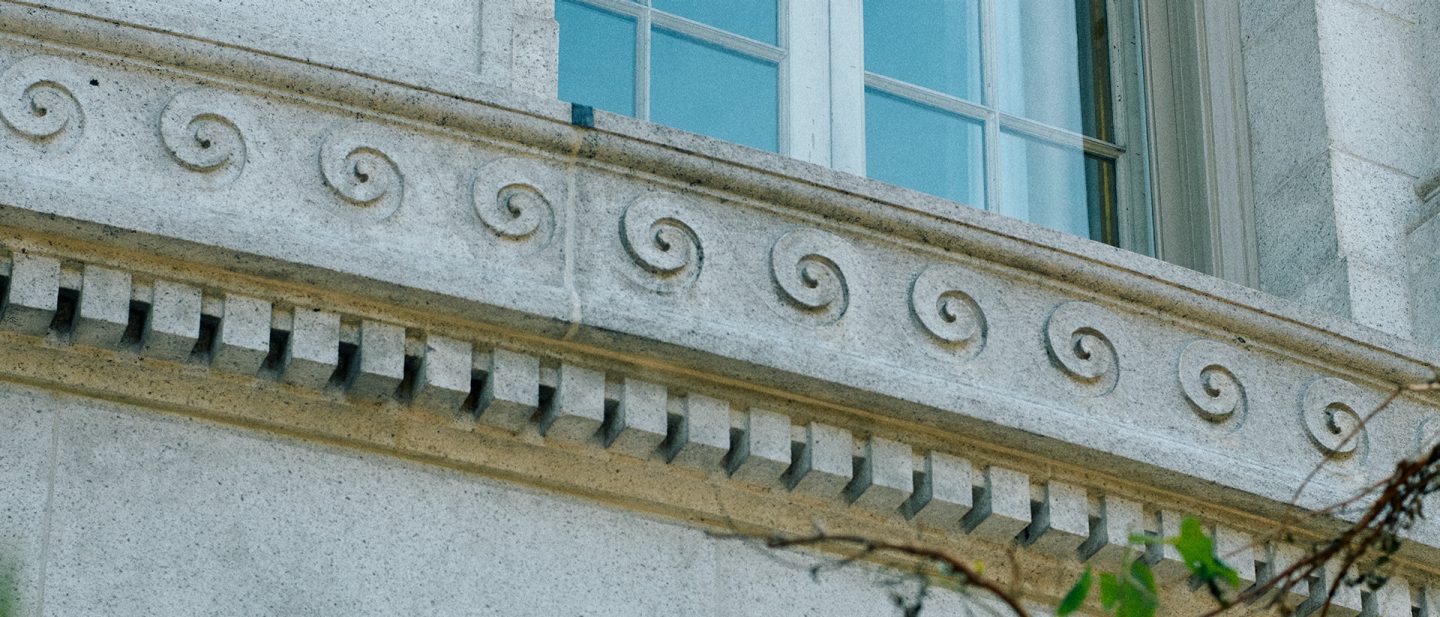 Stone window ledge with spiral ornaments and dentil molding