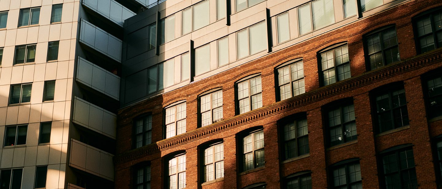 Modern building next to red brick facade in sunlight