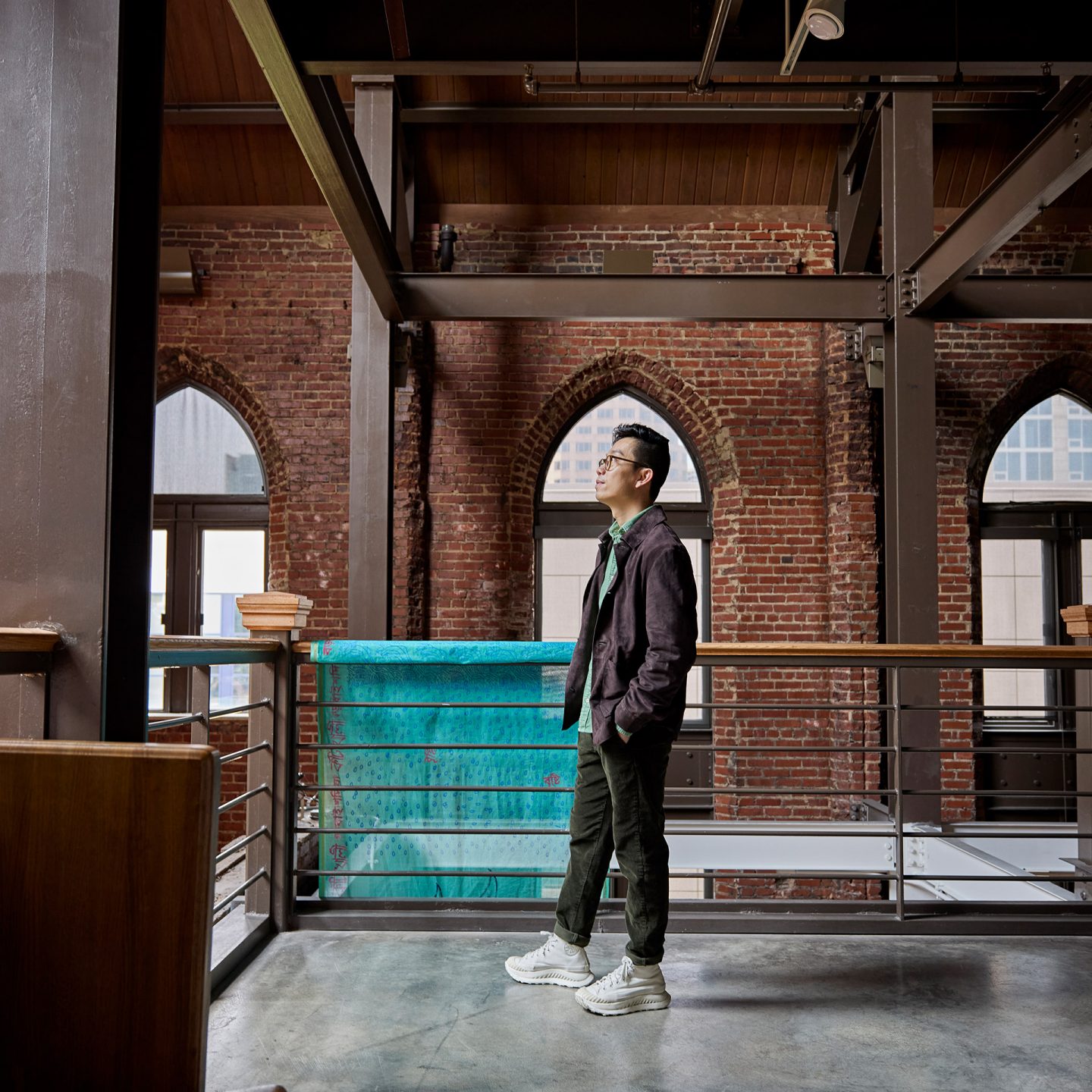 Kenny Nguyen in the McColl Center with red brick walls and large arched windows