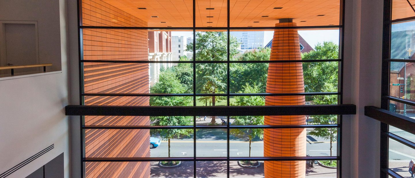 View from the Bechtler Museum through large windows of orange architecture and trees in Charlotte