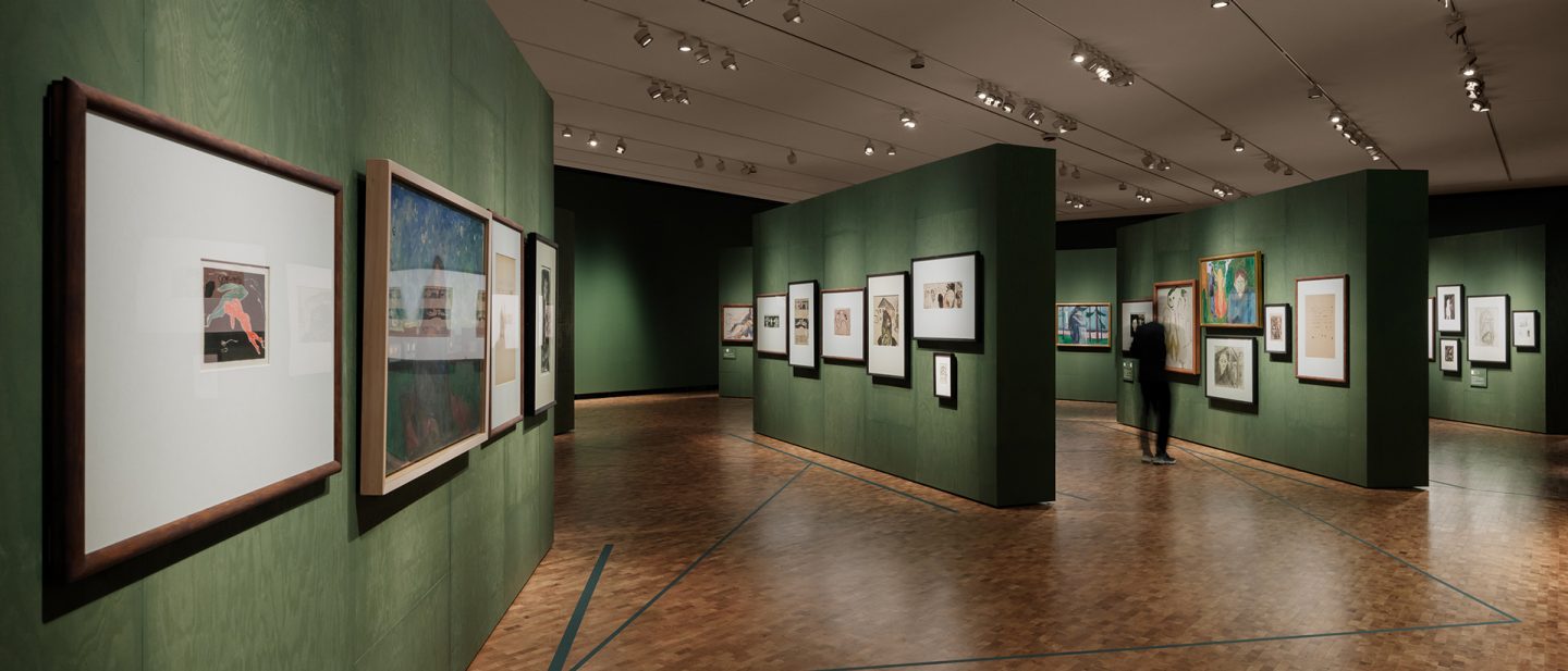 Interior view of the Munch Museum: An art gallery featuring dark green walls, a wooden floor, and framed artworks