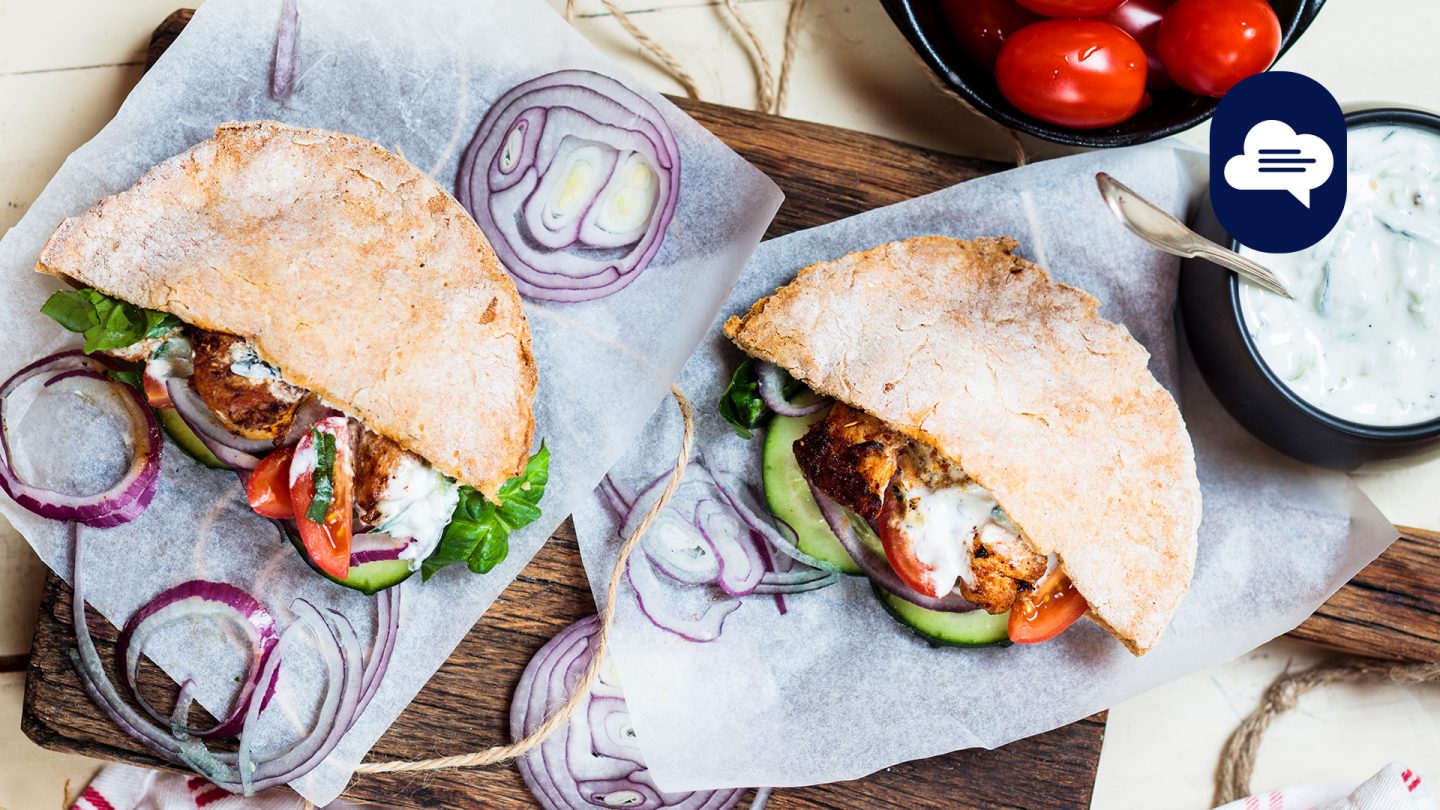 Gyros im Brot serviert auf einem rustikalen Holzbrett