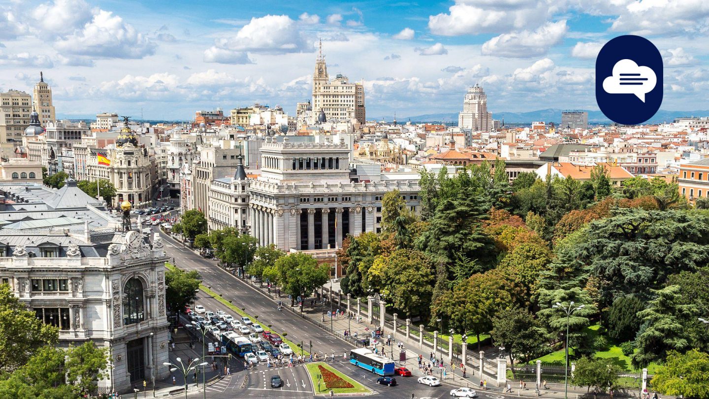 Team Stories: Luftaufnahme der Gran Vía in Madrid mit historischen Gebäuden und Straßenverkehr
